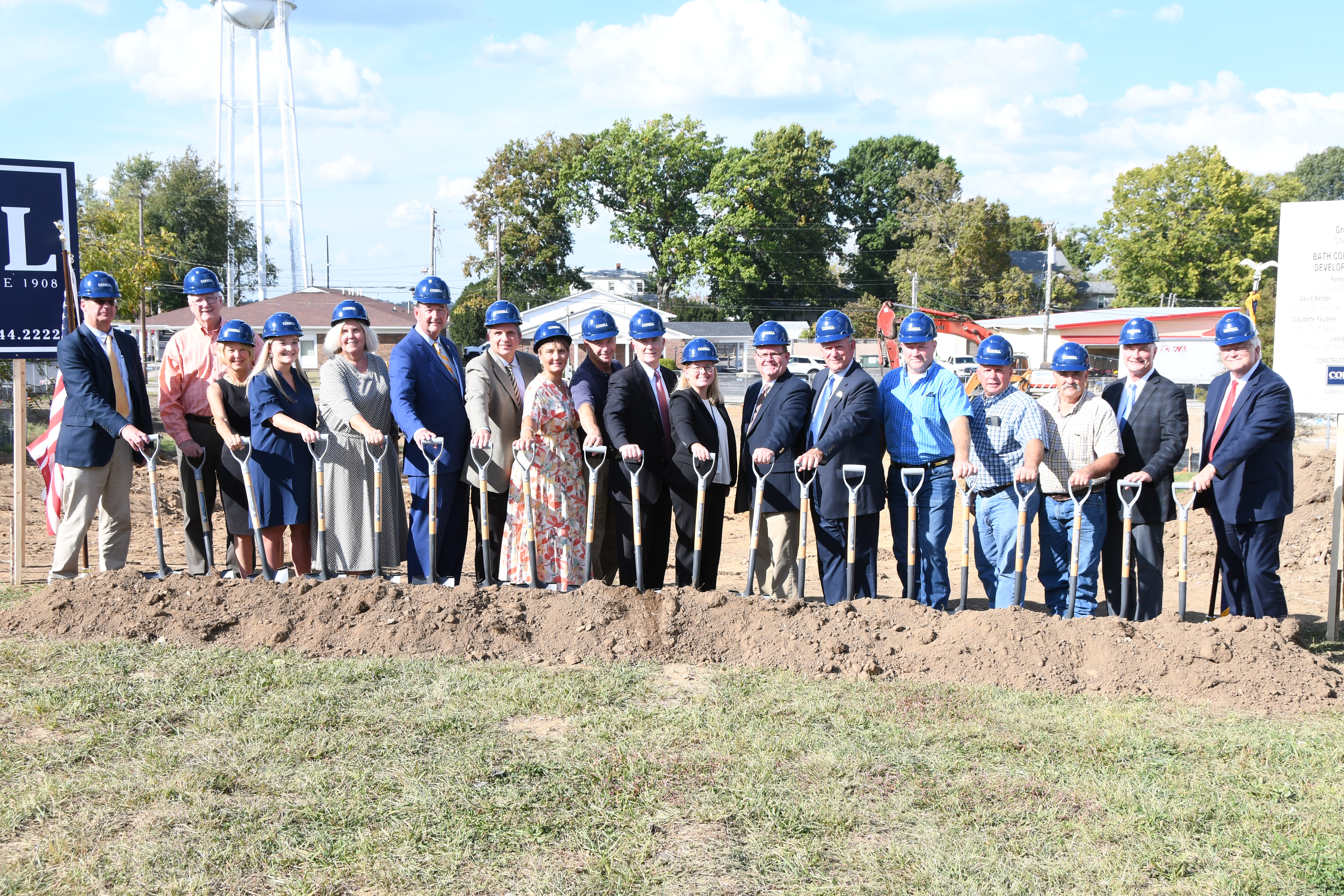 A row of individuals with shovels and hats.