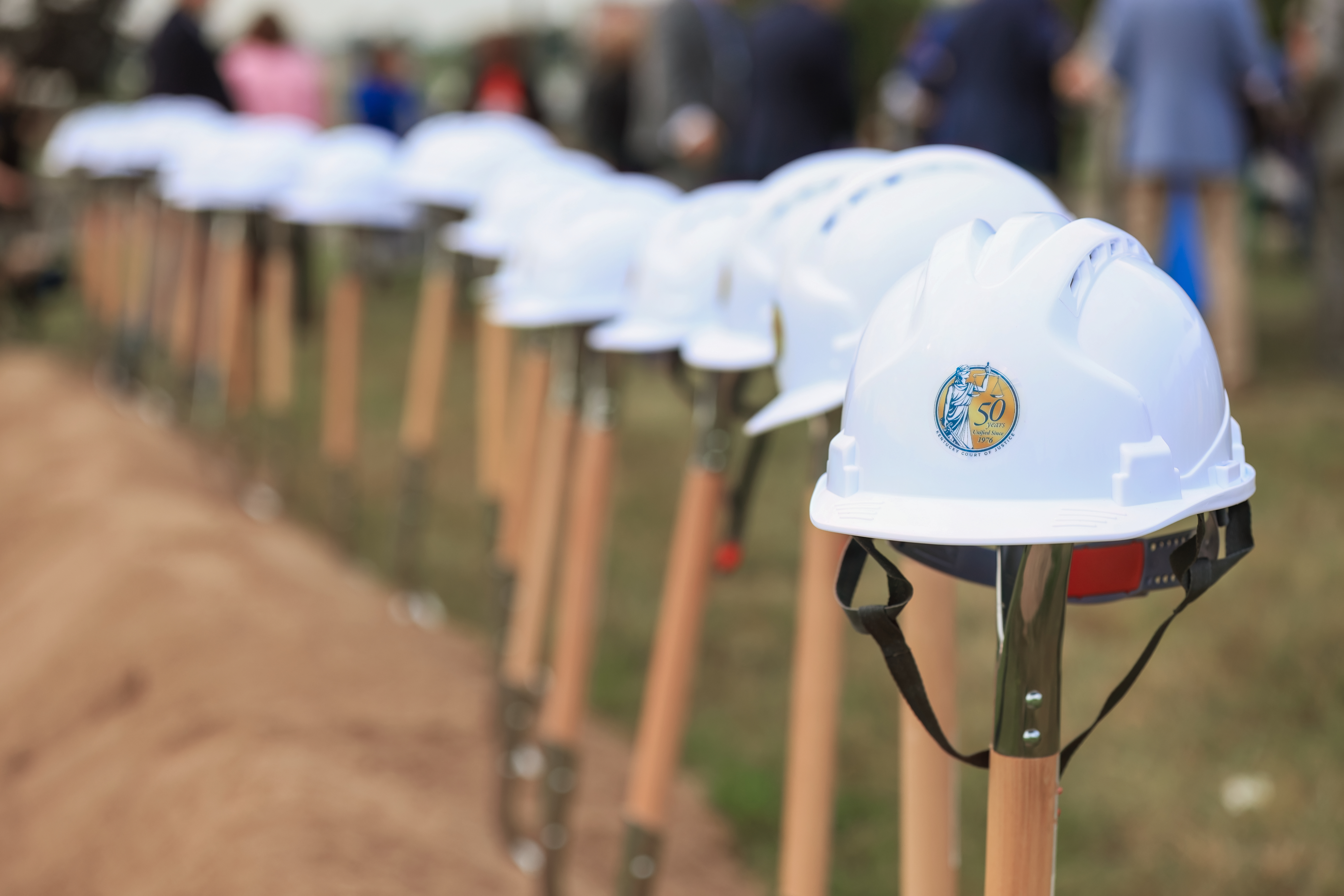 White hard hats sitting on shovels.