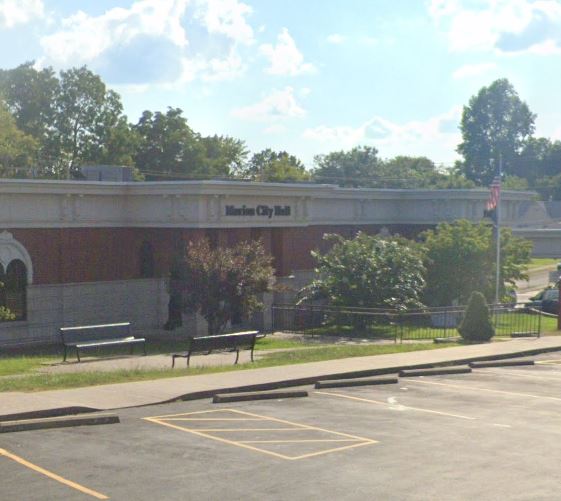 Marion Hall, temporary location for Crittenden County. White and red brick with outside parking lot in front of lobby.