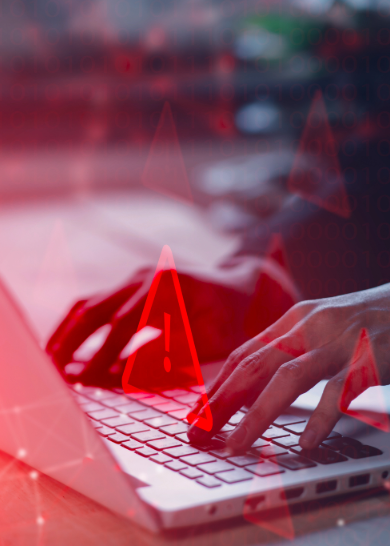 Close-up of hands typing on computer, with red warning symbols. 